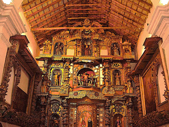 Nave principal del Templo San Jerónimo en Asillo con retablo mayor barroco dorado, numerosas imágenes talladas de santos y techo tradicional de madera