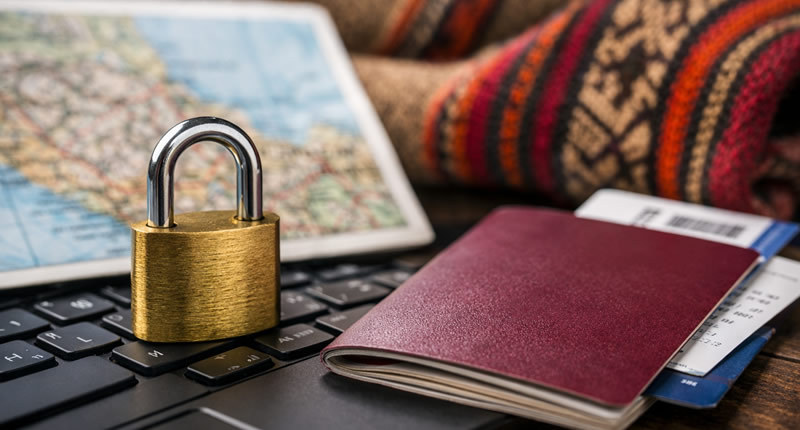 Vorhängeschloss auf Laptop neben Reisepass – digitale Sicherheit beim Reisen in Peru